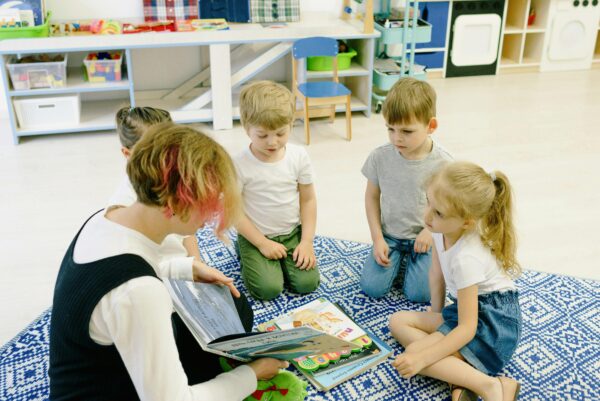 Children gathered around a teacher in a preschool classroom, illustrating how the ZONO™ Cabinet supports clean environments and delivers long-term savings.