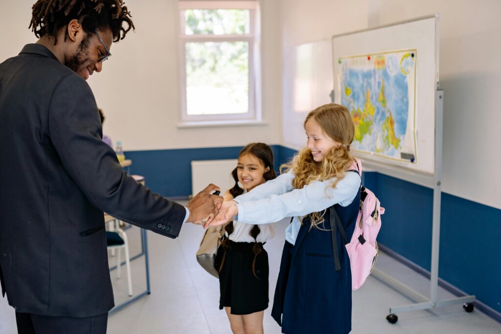 Teacher demonstrating use of a sanitizing cabinet in a classroom setting