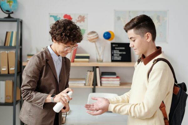 Teacher helping student in a classroom environment – promoting Healthy Tools for a safe, efficient back-to-school start.